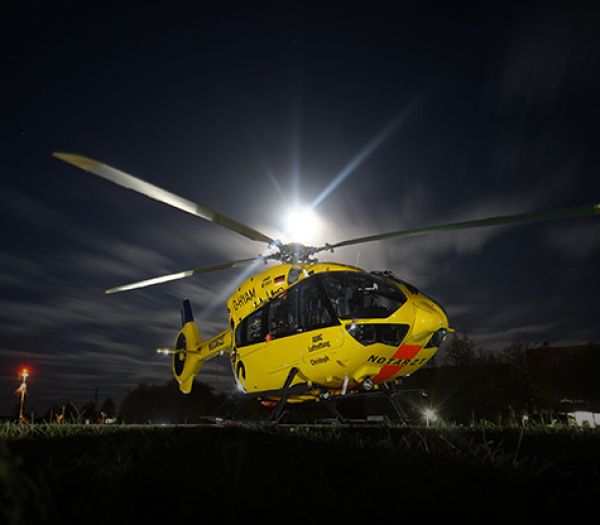 ADAC Luftrettung Rettungshubschrauber nachts auf Landefläche, Rotorblätter und Notarztbeschriftung sichtbar.