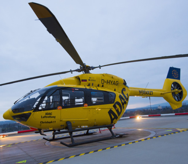ADAC Luftrettung Rettungshubschrauber auf Helipad bei Dämmerung, gelbes Rettungsheli mit Kennung D‑HYAG