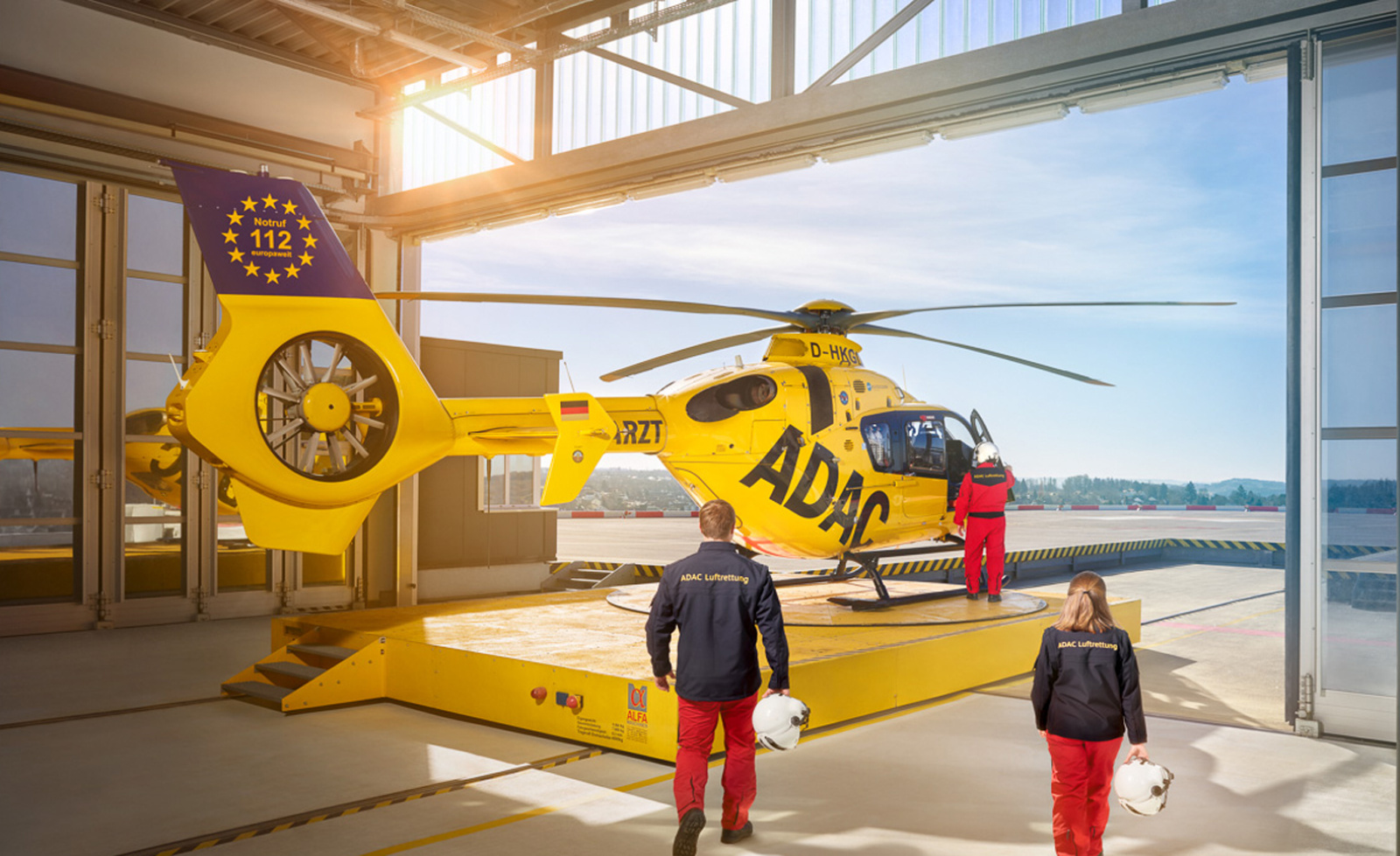 Crew der ADAC Luftrettung vor Rettungshubschrauber beim Jubiläum